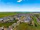 Expansive aerial view of a large neighborhood near open fields and a distant lake at 9566 Poppy Way, Arvada, CO 80007