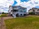 Back exterior of a two-story home with white stairs, a stone facade, and a spacious lawn at 9566 Poppy Way, Arvada, CO 80007