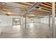 Unfinished basement with insulated walls, exposed beams, and sliding glass door to the outside at 9566 Poppy Way, Arvada, CO 80007