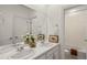 Well-lit bathroom features a double vanity, large mirror, and adjacent toilet and shower at 9566 Poppy Way, Arvada, CO 80007