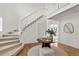 Entryway features a curved staircase and hardwood floors with modern decor and a neutral color palette at 9566 Poppy Way, Arvada, CO 80007