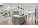 Open-concept kitchen island with stainless steel appliances and access to the bright, airy living room at 9566 Poppy Way, Arvada, CO 80007