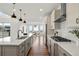 Modern kitchen features stainless steel appliances, a spacious island with seating, and beautiful hardwood floors at 9566 Poppy Way, Arvada, CO 80007