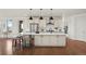 Open kitchen with an island with seating, modern appliances, and hardwood floors at 9566 Poppy Way, Arvada, CO 80007