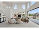 Bright living room with soaring ceilings, a cozy fireplace, large windows, and access to a private deck at 9566 Poppy Way, Arvada, CO 80007