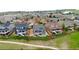 Neighborhood aerial view showcasing fenced yards, fire pits, decks, and walkways, set against a backdrop of green hills at 11817 Phoebe St, Parker, CO 80134