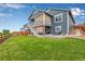 Spacious backyard featuring a large lawn, and a covered patio area with an adjustable awning above the fire pit at 11817 Phoebe St, Parker, CO 80134