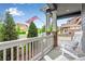 Inviting front porch with rocking chairs, stone pillars, and an American flag at 11817 Phoebe St, Parker, CO 80134