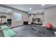 Well-equipped home gym with rubber flooring, weight equipment, treadmill, and bright lighting at 11817 Phoebe St, Parker, CO 80134