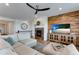A cozy living room featuring a fireplace, wood accent wall, ceiling fan, and comfortable seating at 11817 Phoebe St, Parker, CO 80134