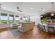 Open concept living room with hardwood floors, a sectional sofa, and large windows overlooking the backyard at 11817 Phoebe St, Parker, CO 80134