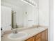 Bathroom featuring double sinks, wood cabinets, and a large mirror at 18846 E Yale Cir # A, Aurora, CO 80013