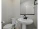 Cozy half-bathroom with modern white pedestal sink and mirror at 17847 E 95Th Ave, Commerce City, CO 80022