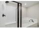 Bathroom featuring soaking tub with shower head and white tiling at 17847 E 95Th Ave, Commerce City, CO 80022