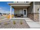 Inviting front porch with stone accents, seating, and a well-manicured landscape at 17847 E 95Th Ave, Commerce City, CO 80022