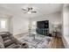 Cozy living room featuring a plush sofa, large TV, ceiling fan, and stylish decor at 17847 E 95Th Ave, Commerce City, CO 80022