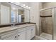 Bathroom featuring double sinks, granite counters, tile floors, and glass enclosed shower at 6031 S Irvington Ct, Aurora, CO 80016