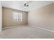 Spacious bedroom featuring neutral walls, carpet, a ceiling fan, and natural light from a window at 6031 S Irvington Ct, Aurora, CO 80016