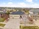 Aerial view of a tan home with stone accents and a three-car garage near a park at 6031 S Irvington Ct, Aurora, CO 80016