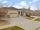 Tan home with a two-car garage, stone accents, and inviting front porch at 6031 S Irvington Ct, Aurora, CO 80016
