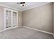 Empty office with French doors, neutral paint, and carpeted floors at 6031 S Irvington Ct, Aurora, CO 80016