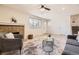 Cozy living room with a brick fireplace, modern seating, and seamless flow to the staircase at 709 S Alkire St, Lakewood, CO 80228