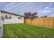 Backyard featuring lush green grass, privacy fence, and the home's exterior at 3656 Fairfax St, Denver, CO 80207