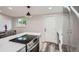 Modern kitchen with white cabinets, stainless steel appliances, and island with a cooktop at 3656 Fairfax St, Denver, CO 80207