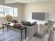 Modern living room with a large window, gray sofa, and a flatscreen TV on the wall at 3656 Fairfax St, Denver, CO 80207