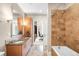 Modern bathroom with dual sinks, granite countertops, and a travertine tile shower and bathtub at 7600 Landmark Way # 904, Greenwood Village, CO 80111