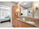 Bathroom with double sinks, granite countertop, and a large mirror, leading to the bedroom at 7600 Landmark Way # 904, Greenwood Village, CO 80111