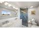 Bright bathroom featuring a marble double vanity and an elegant glass shower with marbled tile, creating a luxurious retreat at 2300 Willow Ln, Lakewood, CO 80215