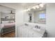 Bright bathroom featuring a marble double vanity and a glimpse into the adjacent bedroom showcasing a comfortable, stylish layout at 2300 Willow Ln, Lakewood, CO 80215