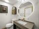 Well-lit bathroom with a modern vanity, round mirror, and stylish fixtures, exuding a clean and contemporary aesthetic at 2300 Willow Ln, Lakewood, CO 80215