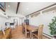 Bright dining area with wood table, white brick wall, and a glimpse of the modern kitchen at 2300 Willow Ln, Lakewood, CO 80215