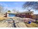 Charming ranch-style home with a blue garage door and well-maintained landscaping at 2300 Willow Ln, Lakewood, CO 80215