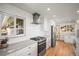 Bright kitchen with stainless steel appliances, white cabinets, and unique patterned backsplash at 2300 Willow Ln, Lakewood, CO 80215