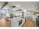 Modern kitchen features an island with marble countertop, stainless steel appliances, and an open floor plan at 2300 Willow Ln, Lakewood, CO 80215