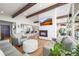 Open-concept living room with a fireplace, hardwood floors, and a modern kitchen in the background at 2300 Willow Ln, Lakewood, CO 80215