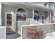 Townhome entrance with covered porch and snow-covered landscaping at 1805 W 101St Ave, Thornton, CO 80260