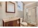 Bathroom with glass door shower, wood vanity, and decorative mirror at 3700-3704 Osage St, Denver, CO 80211