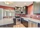 This kitchen features stainless steel appliances, dark cabinets, and a farm sink at 3700-3704 Osage St, Denver, CO 80211