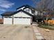 Charming two-story home with a well-maintained yard, stone walkway, and a three-car garage at 19987 E Belleview Pl, Centennial, CO 80015