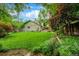 Lush backyard with a large lawn, colorful flowers, mature trees, and inviting outdoor spaces at 3982 Arbol Ct, Boulder, CO 80301