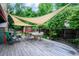 Relaxing backyard deck with sail shades, dining table, chairs, and lush greenery at 3982 Arbol Ct, Boulder, CO 80301