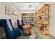 Cozy basement reading nook with wooden bookshelves, comfortable seating, and ample lighting at 3982 Arbol Ct, Boulder, CO 80301