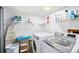 Bright laundry room featuring modern washer and dryer units, shelving, and ironing board at 3982 Arbol Ct, Boulder, CO 80301