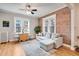 Spacious living area with hardwood floors, exposed brick, and ample natural light at 1341 N Washington St # 4, Denver, CO 80203