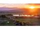 Stunning aerial view of the property, showcasing the expansive landscape and vibrant sunset over the mountains at 13183 N 95Th St, Longmont, CO 80504