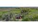 Expansive aerial view of a red barn, surrounded by green fields and mature trees, enclosed by a wooden fence at 13183 N 95Th St, Longmont, CO 80504